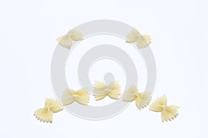 A sad smiley, laid out of pasta on a white surface.