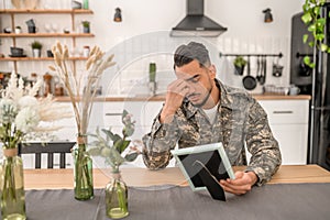 Joyless military man with a photograph in the hand photo