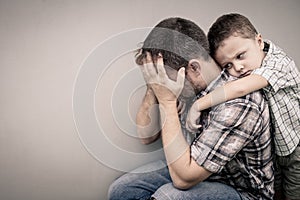 Sad son hugging his dad photo