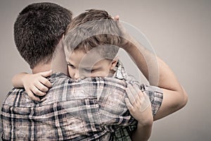 Sad son hugging his dad