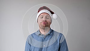 The sad and sorrowful European young man in a New Year's hat looks gloomily into the camera.