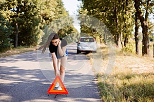 Sad student girl putting red emergency triangle stop sign