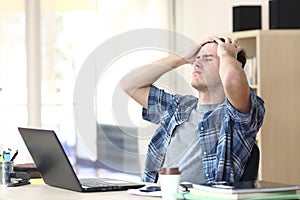 Sad student with laptop complaining at office