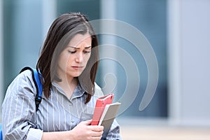 Sad student walking alone in a campus