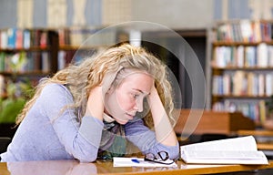 Sad student working in library