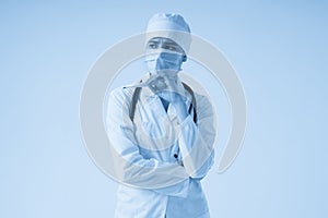 Sad surprised doctor wearing medical face mask holding medical thermometer over white background