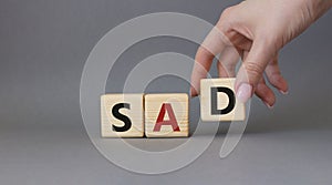 Sad symbol. Wooden cubes with words Sad. Businessman hand. Beautiful grey background. Business and Sad concept. Copy space