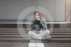 Sad teen girl on a bench in the park. Single girl outdoor. Lonely sad girl