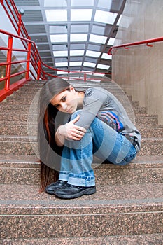 Sad teen girl on school stairs