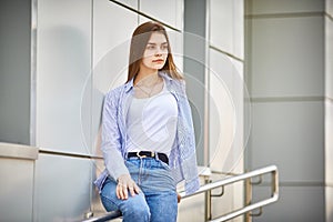 Sad teen girl with sitting on the railing of a building. Psychological problems of teenagers