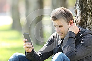 Sad teen reading phone messages photo