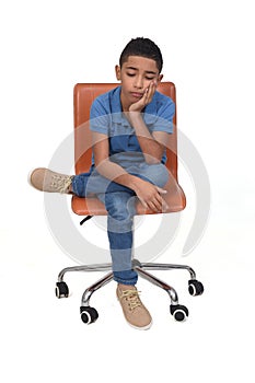 Sad teen sitting on a chair  on white