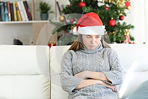 Sad teen sitting on a couch in christmas time at home