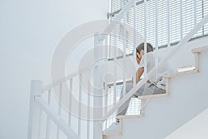 Sad teenage boy with backpack sitting on school stairs. Education, learning difficulties, psychological problems, stress