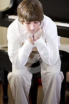 Sad teenage boy sitting with chin on hands