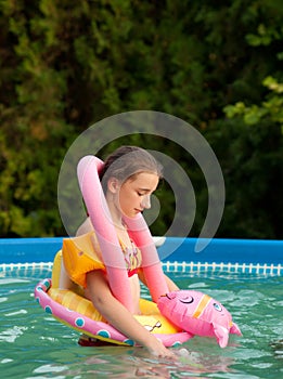 Sad teenage girl playing alone in the pool