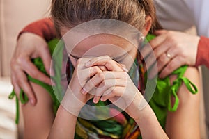 Sad teenage girl propping her head in despair - woman hands holding and comforting her