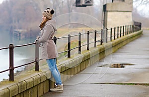 Sad teenage girl standing outside on cold winter day