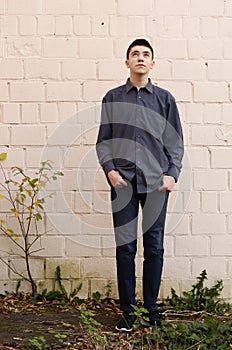Sad teenager boy full body photo on white wall background