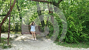 Sad teenager girl swinging on a swing in the park