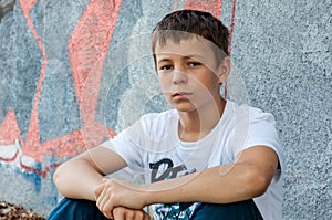 Sad teenager outdoors near the wall