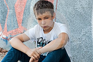 Sad teenager outdoors near the wall