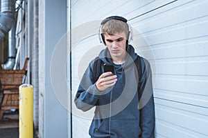 Sad teenager wearing headphones and listening to music.