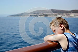 Sad thoughtful little boy looking at the sea