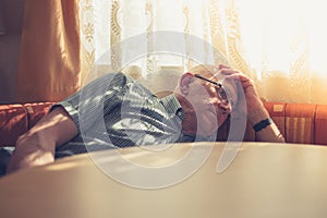 Sad and tired old man by window