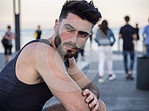 Sad, troubled, worried young man on seaside promenade