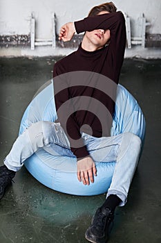 Sad unhappy depressed man sitting closing his eyes with arm depression concept