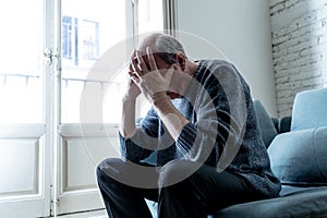 Sad unhappy old senior man suffering from memory loss and alzheimer feeling depressed and lonely