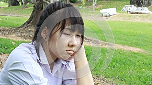 Sad Unhappy thai student teen Sitting On Park