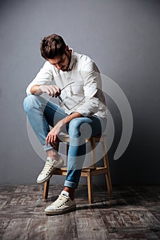 Sad upset young man sitting and looking down