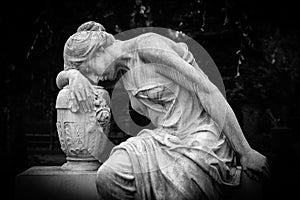 Sad and weeping woman sculpture. Sad grieving expression sculpture with sorrow face down thinking crying. Black and white BW photo