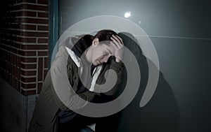 Sad woman alone leaning on street window at night suffering depression crying in pain