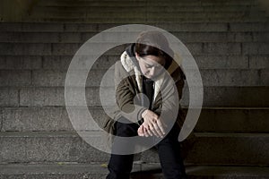 Sad woman alone on street subway staircase suffering depression looking looking sick and helpless