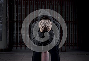 Sad woman alone on street suffering depression desperate and helpless wearing hoodie