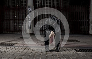 Sad woman alone on street suffering depression desperate and helpless wearing hoodie