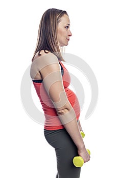 Sad woman with a belly in sportswear with dumbbells in her hands. Sports, fortitude and endurance. Isolated on a white background