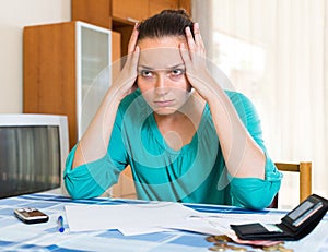 Sad woman with bills at the table