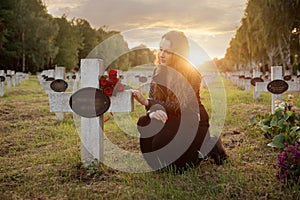 Sad woman in the cemetery .