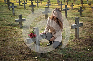 Sad woman in the cemetery .