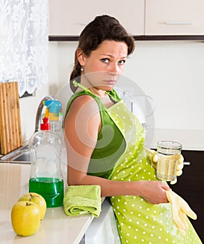 Sad woman cleaning furniture