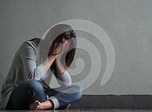 Sad woman closed her face and cry while sitting alone