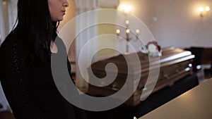 Sad woman and coffin at funeral in church