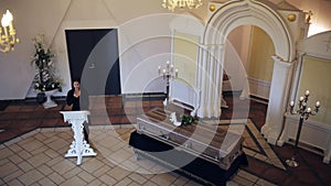 Sad woman and coffin at funeral in orthodox church