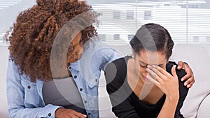 Sad woman crying next to her therapist photo