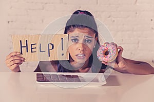 Sad woman on diet holding a sign help resisting temptation to eat chocolate and donuts