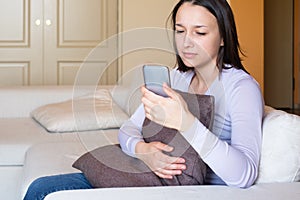 Sad woman discovering boyfriend cheating on smartphone